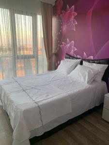 ein Schlafzimmer mit einem großen weißen Bett mit einer lila Wand in der Unterkunft İSTANBUL, KOZA PARK in Bahcesehir