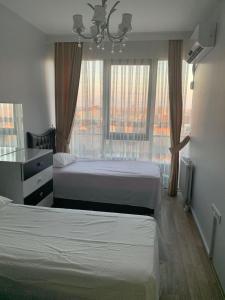 een hotelkamer met 2 bedden en een raam bij İSTANBUL, KOZA PARK in Bahcesehir
