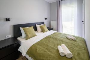 a bedroom with a large bed with two towels on it at Comfortable and spacious oasis in Krakow