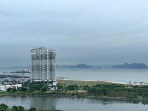 a tall building next to a large body of water at Mon Cherry Apartment -Greenbay Garden Ha Long in Ha Long