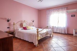 - une chambre avec un lit blanc et une fenêtre dans l'établissement L' uliveto, à San Piero Patti