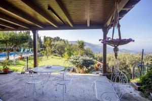 d'une terrasse avec une table et des chaises et une vue. dans l'établissement L' uliveto, à San Piero Patti