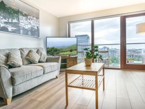 a living room with a couch and a table at Pass the Keys Incredible Cityscape Views Balcony City Centre in Belfast
