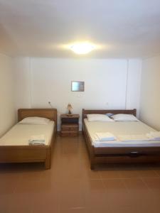 twee bedden in een kamer met twee tafels bij Selini Studios in Koufonisia