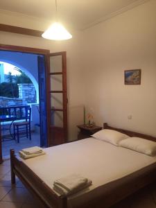 a bedroom with a bed and a door to a patio at Selini Studios in Koufonisia