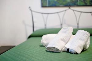2 rollos de toallas en una cama verde en Le terme, borgo dei pescatori en Cervo