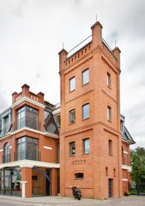 a red brick building on the side of a street at Loft Amalia w wieży strażackiej, butikowy, blisko jeziora in Szczecinek