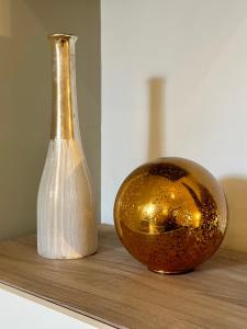 a bottle and a vase sitting on a table at LE PANCAUT- Chaleureux - Hyper Centre in Mont-de-Marsan +3 photos