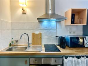 a kitchen with a sink and a microwave at LE PANCAUT- Chaleureux - Hyper Centre in Mont-de-Marsan