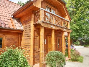 a wooden house with a balcony on the side of it at Strandschlösschen Sellin - House Half 3 in Ostseebad Sellin