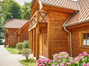 a wooden house with flowers in front of it at Strandschlösschen Sellin - House Half 3 in Ostseebad Sellin