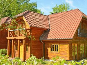 a log home with an orange roof at Strandschlösschen Sellin - House Half 3 in Ostseebad Sellin