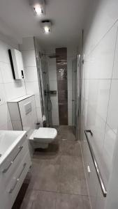 a bathroom with a shower and a toilet and a sink at Luxus Appartement im Zentrum Düsseldorfs in Düsseldorf