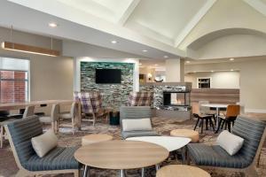 a lobby with tables and chairs and a fireplace at Residence Inn By Marriott Vacaville in Vacaville