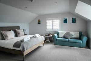 a bedroom with a bed and a blue couch at Macdonald's Farm in Saint Ervan