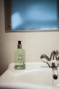 a bottle of soap sitting on a bathroom sink at Macdonald's Farm in Saint Ervan