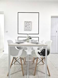 Biały stół jadalny z białymi krzesłami w obiekcie Meritus Service Apartment w mieście Perai