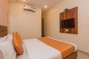 a bedroom with a bed and a tv on the wall at Hotel Golden Nest Near Chhatrapati Shivaji International Airport in Mumbai