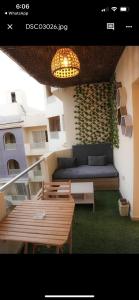 a balcony with a couch and tables and a light at Binishty hurghada apartment in Hurghada