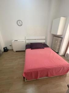 Un dormitorio con una cama y un reloj en la pared. en Casa Vacanza Torino, en Turín