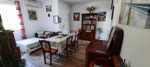 sala de estar con mesa, sillas y sofá en gîte Aux Tourterelles, en Tournemire