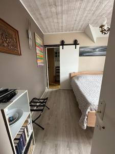 a small bedroom with a bed and a table at Villa les Buissonets in Berck-sur-Mer