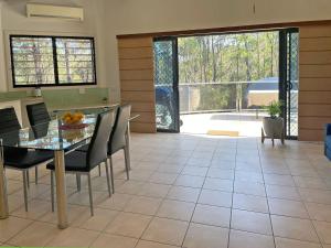 een keuken en eetkamer met een tafel en stoelen bij Lush 2Bedroom Apartment in Yamba Hinterland in Ashby