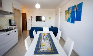 un comedor con una mesa blanca y un sofá azul en EMMEA8 APARTMENTS RELAX, en Angri