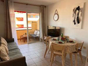 una sala de estar con una mesa y un sofá en Jardín, en Puerto de Santiago