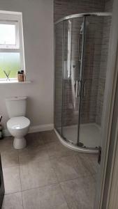 a bathroom with a shower and a toilet at Stunning New 3 Bed Townhouse in Belmullet