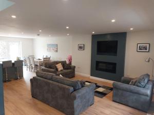 Sala de estar con 2 sofás y TV en Stunning New 3 Bed Townhouse, en Belmullet