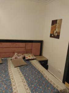 a bedroom with a bed with a wooden head board at الرحاب دار مصر القرنفل in Cairo