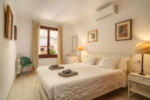 アルクーディアにあるApartamento CAN PERICAS Alcudiaのベッドルーム1室(白いベッド1台、タオル2枚付)