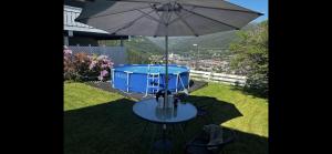 stół z parasolką obok niebieskiego bębna w obiekcie B&B i flott utsiktseiendom Otta w mieście Otta