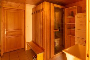 a kitchen with wooden cabinets and a sink and a refrigerator at Chalet R'Mize in Les Gets