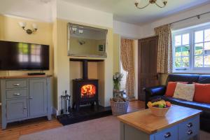 a living room with a couch and a fireplace at Bumble Bee Cottage in Burley