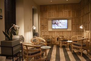 una sala de espera con sillas de mimbre y TV en room Select Liberdade en Lisboa