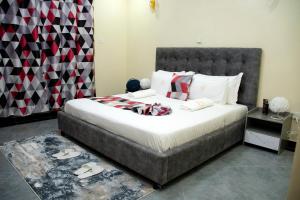 um quarto com uma cama grande e uma cabeceira cinzenta em The Haven254 em Nakuru