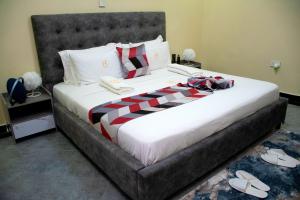 um quarto com uma cama grande com sapatos no chão em The Haven254 em Nakuru