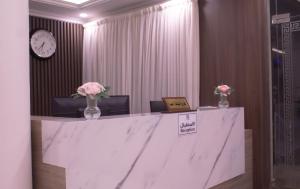 منازل الريم (فرع العزيزية) في الرياض: كونتر رخام مع مزهريات من الزهور وساعة