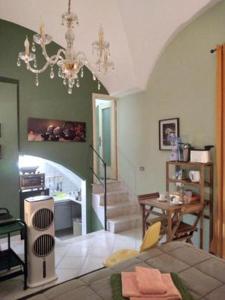 sala de estar con escalera y lámpara de araña en Armony House, en Trecastagni