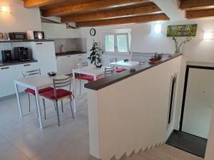 kuchnia z białymi blatami oraz stołem i krzesłami w obiekcie Tana del Riccio w mieście Ortona