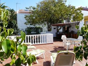 un patio con sillas y mesas y una valla blanca en Casa Flora Garden Studio (Gite), en Sauzal