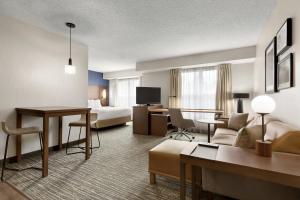 um quarto de hotel com uma cama e uma sala de estar em Residence Inn Houston The Woodlands/Market Street em The Woodlands