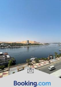 Aswan sunrise في أسوان: اطلاله على جسم ماء مع مدينه