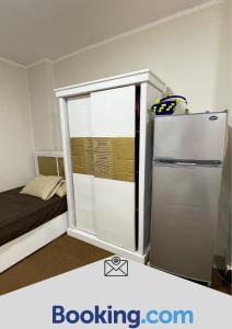 um pequeno quarto com um frigorífico e uma cama em Aswan sunrise em Aswan