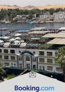 Un gran edificio blanco al lado de un cuerpo de agua. en Aswan sunrise, en Asuán