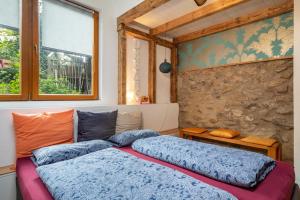 een slaapkamer met 2 bedden en een stenen muur bij Artesana 2 Bleichnau in Tettnang