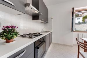 een witte keuken met een fornuis en een wastafel bij Chalet La Greta - Casa vista campi in Firenzuola