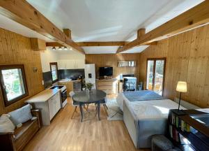 Cet appartement comprend une chambre avec un lit et une table ainsi qu'une cuisine. dans l'établissement Chalet in green, sunny and quite spot 5’ from center, à Chamonix-Mont-Blanc